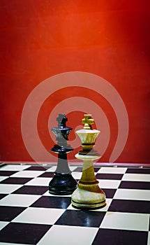 Shot of the confrontation between white and black chess pieces standing on a chessboard