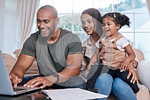 Its never to early to start investing for her future. Shot of a couple and their little daughter using a laptop at home.