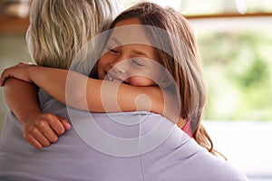 Giving granny a big hug. Shot of a cute little girl hugging her grandmother.