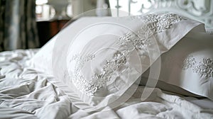 A shot of a detailed embroidery design on a set of crisp white pillowcases showcasing the intricate craftsmanship of the