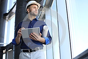 Shot of a engineer using a digital tablet on a construction site. This software help me to keep track of everything