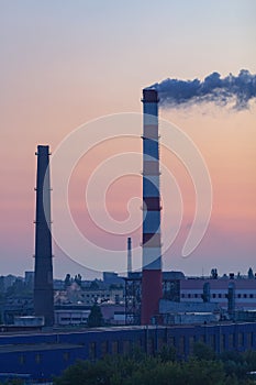 Shot of exhaust pipes and factory buildings in the early morning