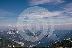 Shot of an extreme athlete parachuting from the Krippenstein mountain part of the Dachstein massif. Gliding through the air.