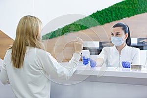 Shot of a female person being measured body temperature with a contactless thermometer by the employee of the reception