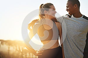 Keeping each other healthy and happy. Shot of a fit young couple working out together outdoors.