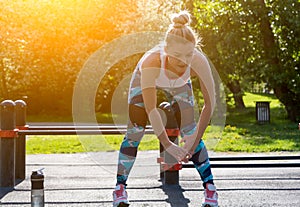 Shot of fit young woman stretching at urban park. Chinese female model in sportswear doing warm up exercise at park in