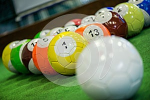 Shot of foot pool balls standing on green table.