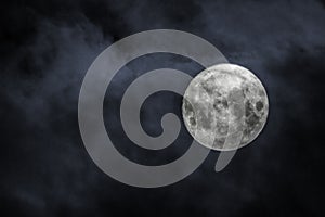 Shot of the full moon with clouds on black sky