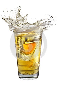 A shot glass filled with alcohol, placed inside a glass with beer. Splash