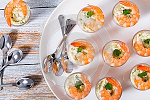 Shot-Glass Shrimp with tartar sauce - easy cocktail recipe for festive party, on white platter with spoons on old white wooden tab