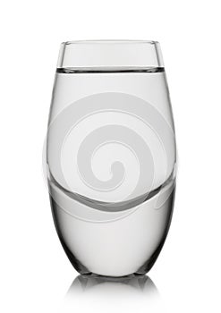 Shot glass with tequila or cold clear vodka alcohol drink on white background