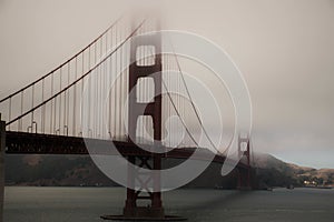 Shot of the Golden Gate Bridge in San Francisco in foggy weather and under the dark sky