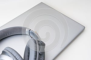 Shot of a gray headphone on a gray laptop isolated on a white background