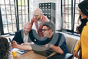 Shot of a group of young business professionals having a meeting. Diverse group of young designers smiling during a