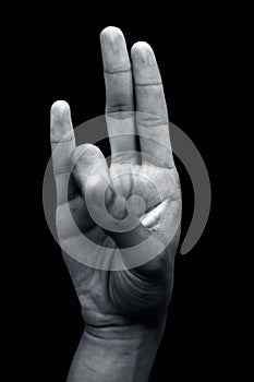 Shot of a hand doing Agni yoga or Surya Mudra or Gesture Of The Fire mudra isolated on black background.
