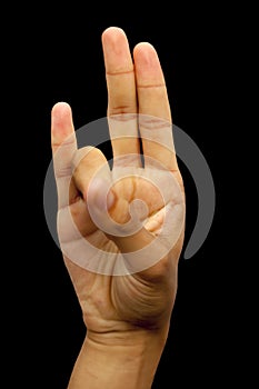 Shot of a hand doing Agni yoga or Surya Mudra or Gesture Of The Fire mudra isolated on black background.