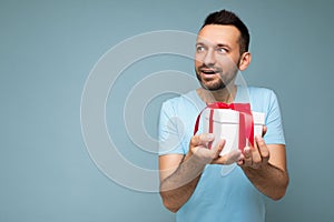 Shot of handsome happy smiling brunet young male person with beard isolated over blue background wall wearing blue t