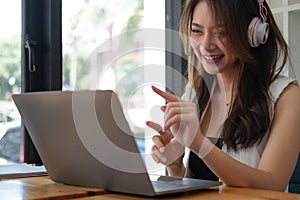 Shot of Happy asian business woman wears headset online video conference call on laptop computer with her business team