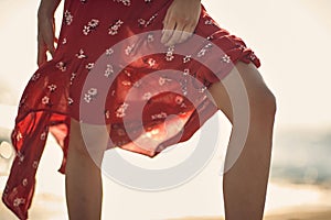 Shot of legs of woman in red dress posing. Fashion, summertime, lifestyle concept