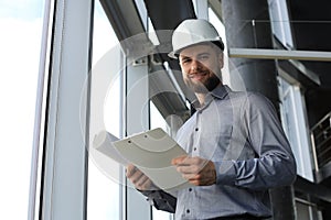 Shot of male architect wearing hardhat and inspecting new building