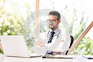 Thinking male doctor sitting in the doctor`s office photo