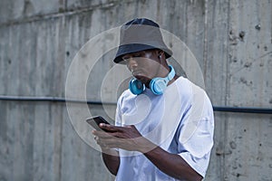 Shot of a man with white t shirt and a blue headset standing in the street and using phone, Spain