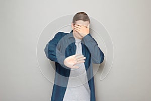 Shot of mature man is covering his face with hand protecting himself