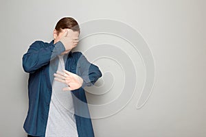 Shot of mature man is covering his face with hand protecting himself