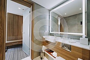 Shot of a minimalistic bathroom with an open door facing the guest room