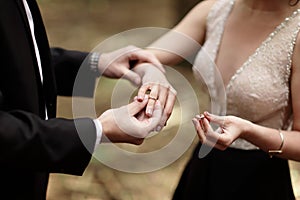 Shot moment when the groom puts the ring on a young bride`s hand