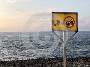 Shot of a no swimming sign in the beach