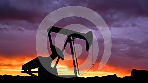Shot of oilfield crane over sunset sky background. Large drilling rig tower head extracting crude oil from the soil.
