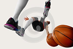 Shot of one young streetball player wearing sport uniform and moving with ball over white background