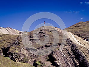 Shot of a person contemplating the snowy mountains heading to the rainbow mountain in Cusco, Peru.