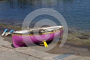 Shot of a pink skiff boat parked at the seashore on a beautiful spring day