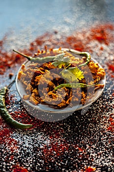 Shot of Piyaz pakora/bhaji/bhajji/bhajiya/bajji in a glass plate with some fresh green chilies and red chili powder along with it photo