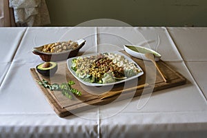 Shot of a plate with delicious salads, cheese cubics on a wooden board guacamole and bread cubics