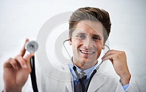 This is going to feel cold. Shot of a positive-looking doctor holding up the end of a stethoscope toward the camera.