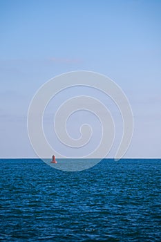 Shot of a red marker for a shipping channel in the middle of the sea