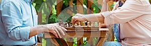 Shot of retired couple playing chess on wooden table