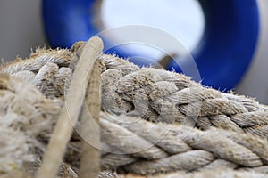 A shot of a rope with a blue ship window on the background