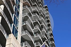 A shot of rows of balconies with gray metal rails on the side of a building with blue sky in Atlanta