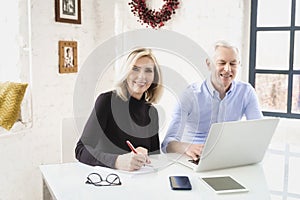 Shot of a senior couple using a laptop together at home while sitting at desk