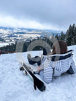 Shot of a skier woman sitting on the ski slope resting relaxing extreme recreation active lifestyle activity. Female