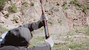 Shot from a sniper rifle at a target on the shooting range. The shooter is falling from a strong impact.