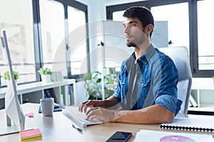 Software developer working with computer in the modern startup office photo