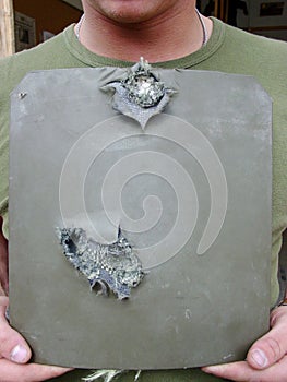 Shot of a soldier holding up pierced body armor- this is the real thing from KFOR, Kosovo 1999. This image is part of