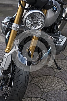 Portrait of a detail of a Bmw r nineT with a zoom on the front headlight