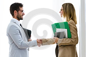 Two attractive bussines partners shaking their hands in the office. photo