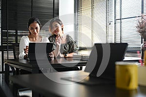 Shot of two businesswomen are using computer tablet and discussing new project a office.